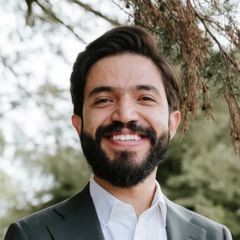 A man, J. Camilo Chacón-Duque, smiles and looks at the camera.